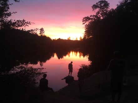 rafter's reflection on the river during sunset