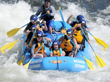 family rafting in rapid