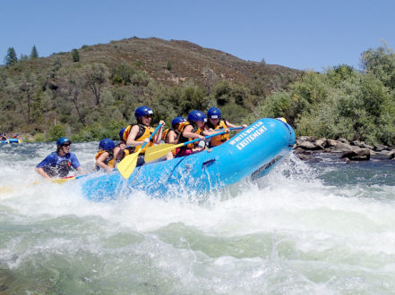 river raft crashing through rapid