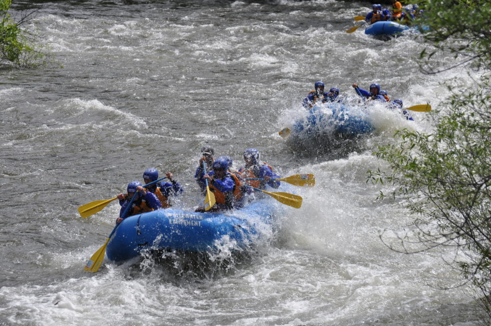 three rafts going down the river in whitewater